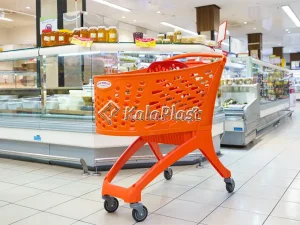 سبد خرید چرخدار فروشگاهی نارنجی مقابل یخچال‌های ویترینی فروشگاه